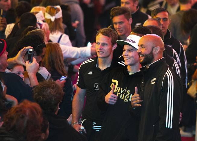 USA Sevens International Rugby Tournament players from New Zealand pose with a fan on the red carpet during a parade and opening ceremonies at the Fremont Street Experience on Thursday, Jan. 23, 2014.